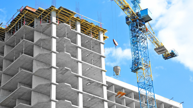 Building construction site with crane overhead